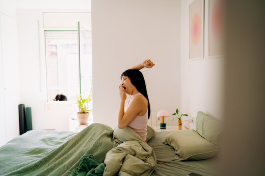 A woman stretching in bed