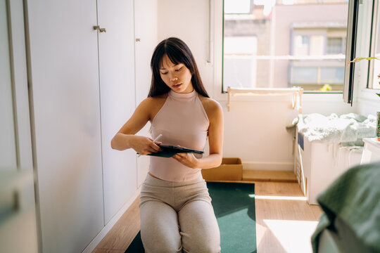A woman turns on a yoga video on her tablet