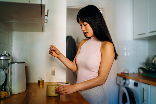 A woman making tea in the kitchen