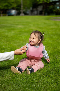 Baby Girl Smiling While Eating Fruit During London Outing