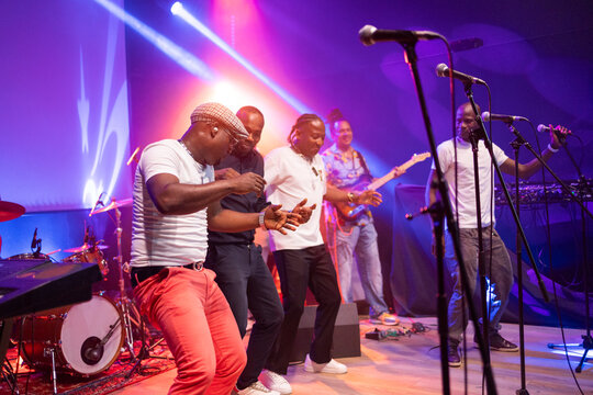 Group of men dancing performing live music concert