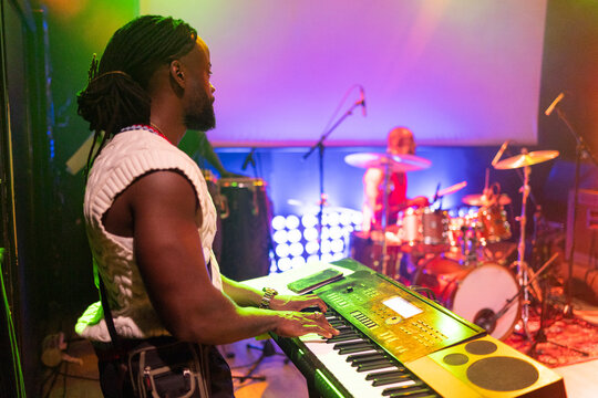 Musician playing keyboard during a live concert performance