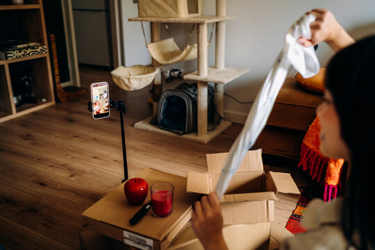 A woman opening a box sitting on the floor