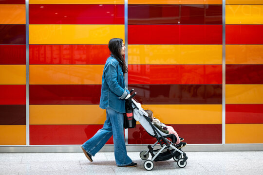 Mother Walking With Baby Girl Past Colorful Wall In London