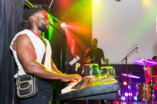 African man performing live playing keyboard at concert