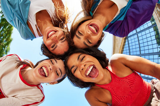Friends laugh joyfully together under the blue sky
