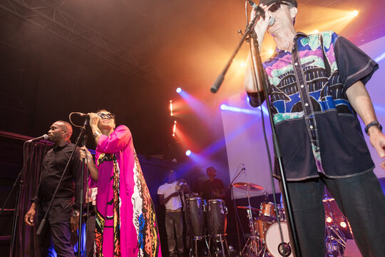 Musicians performing live in vibrant stage lights during concert
