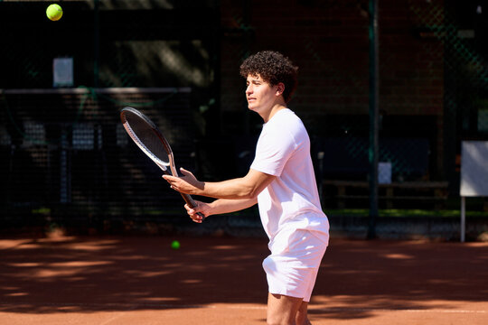 Tennis Player Prepares to Hit a Ball on a Red Clay Court