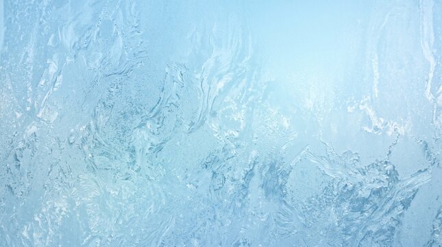 Frosted glass texture with blue glow. Abstract icy window pattern for winter background.