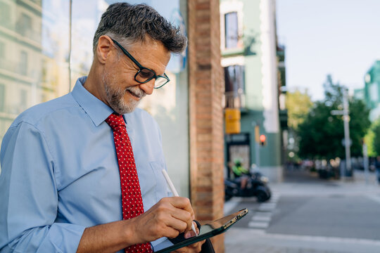 A businessman using a tablet in the city