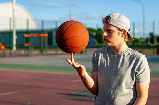 Teen boy balancing basketball on finger