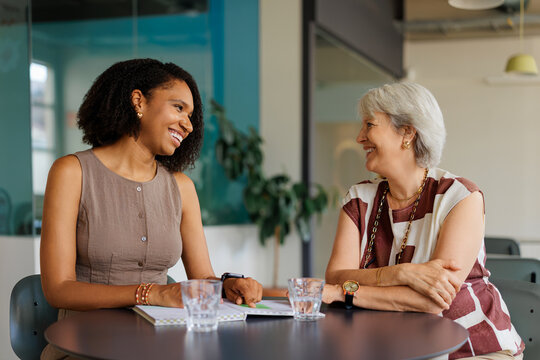Female professionals collaborating and smiling during office meeting