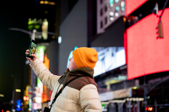 takes a selfie in New York Times Square
