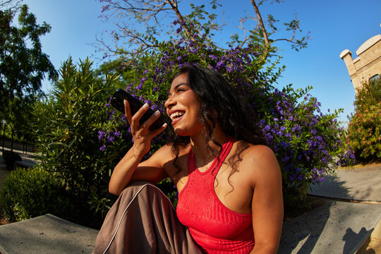 Woman enjoys conversation while sitting outdoors in the park