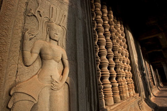 Sandstone devata and ancient columns in Angkor Wat