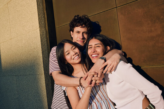 Three Friends Hugging and Laughing Outdoors