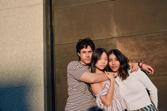 riends Embracing Against Urban Wall