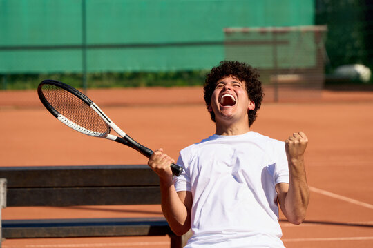 Young Player Celebrates Victory After Winning a Tennis Match