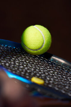 Tennis Ball Resting on a Racket Before a Serve