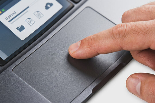 Person using a trackpad on a laptop with file upload interface