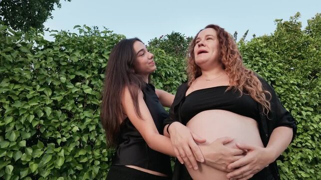 Pregnant woman enjoying quality time with her family and relaxing by the swimming pool in a natural outdoor setting