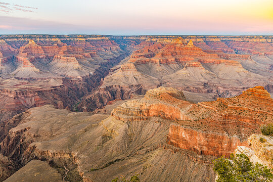 Golden sunset light illuminates layered canyon walls and buttes at the Grand Canyon's South Rim, Arizona.