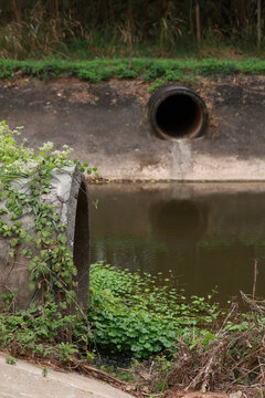 Concrete circular run-off pipe discharging water. sewage pipe polluting the river. Sewage or domestic wastewater or municipal wastewater that is product by community of people.