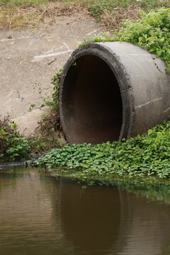 Concrete circular run-off pipe discharging water. sewage pipe polluting the river. Sewage or domestic wastewater or municipal wastewater that is product by community of people.