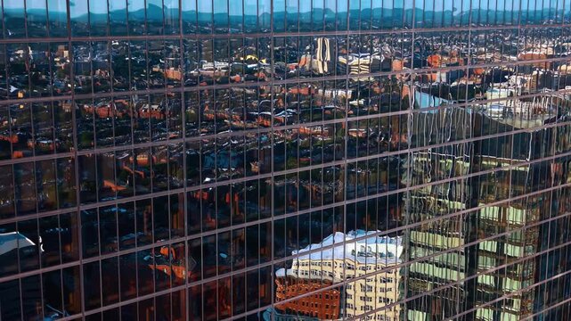 Mirror facade of modern high-rise reflecting the cityscape. Drone footage at the windows of 200 Clarendon in Boston, Massachusetts, USA.