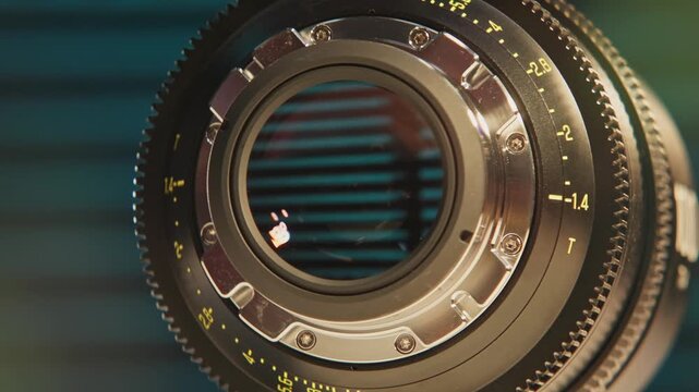Slomo close up of cinematography glass equipment of an expensive cinema lens for large format cameras and camera technology as rear and front elements show iris, aperture, focus, and distance marks 4k
