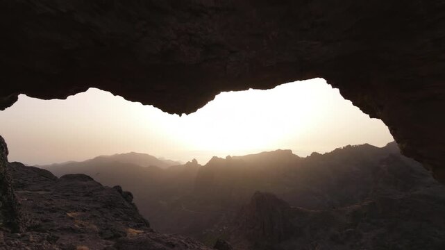 Beautiful sunset over the mountains of Gran Canaria viewed from the iconic Ventana del Nublo rock formation, with a kestrel flying near