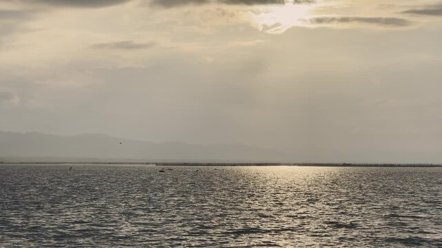 Sunlight Reflecting on Water Surface with Distant Mountains