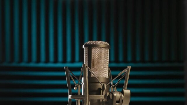 Slow motion colorful studio shot of voiceover dialogue podcast microphone on stand in close-up detail with acoustic foam in recording space with dark background and bright lighting of broadcast vo mic