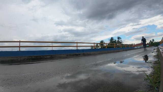 Slow Motion of Man Riding Bicycle on Wet Road