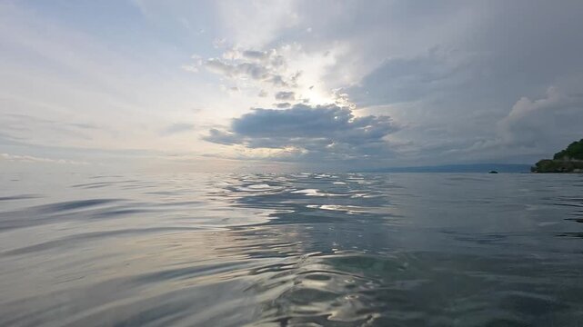 Slow Motion of Calm Ocean Surface Under Cloudy Sky