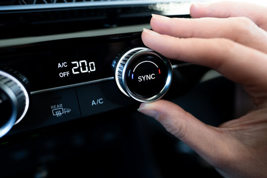 woman hand pressing AC off button on modern dark car dashboard climate control panel with temperature screen set to 20 degrees for eco driving and comfort