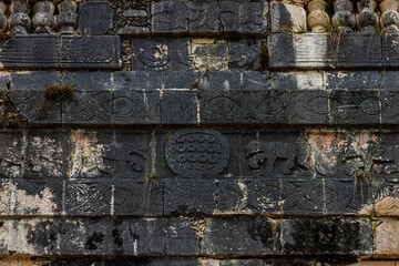 Close up of the dark stone relief carvings with jaguar figures and spiral motifs on the Jaguar Temple in Chichen Itza, Mexico © simonmayer