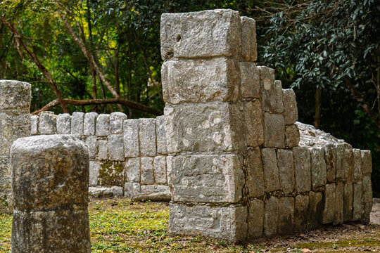 Close up of the weathered stone columns and masonry walls of the Xtoloc Temple hidden in the jungle at Chichen Itza, Mexico