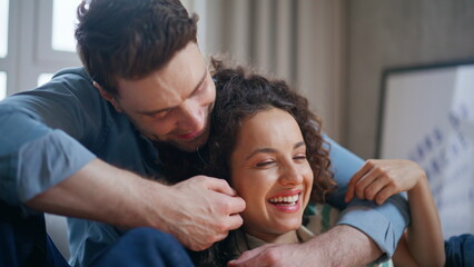 Fototapeta premium Smiling couple bonding home closeup. Boyfriend embracing happy girlfriend sofa.