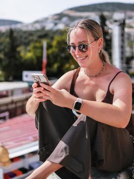 Female traveler with smartphone in old town street, solo travel, city break, sightseeing, navigation and authentic summer tourism lifestyle
