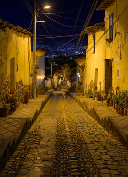 Night street in Cusco, Peru, climbing on a steep hill slope.