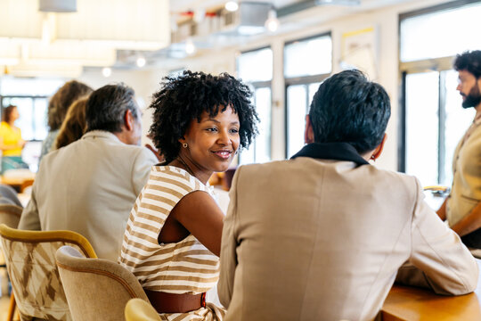 Diverse business people engaging in conversation and working together in a vibrant, flexible, and inclusive office environment