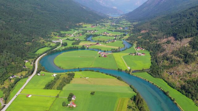 Aerial drone view of a winding river in a mountain valley near Stryn, Norway. Scenic water landscape, high peaks, and popular Scandinavian travel destination.