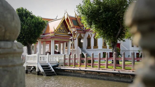 Ornate Temple Building With Gabled Roof Beside Water And Decorative Fence