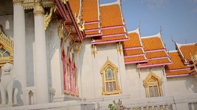 Ornate Temple With Gold Gabled Roof And Decorative Columns In Sunlight