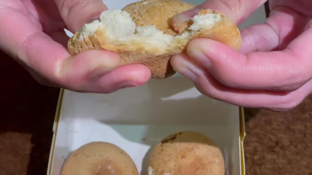 Hand holding creamy durian filled cream puff