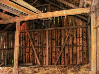 Naklejka premium Interior of an empty old wooden barn prepared for storing hay in a village