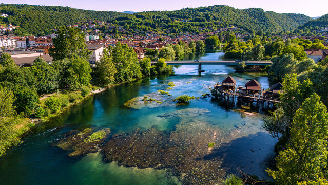 Aerial view of Bosanska Krupa town and turquoise Una river in Bosnia and Herzegovina during golden hour
