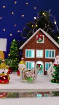 A quirky Santa Claus pops out against the backdrop of a Christmas town