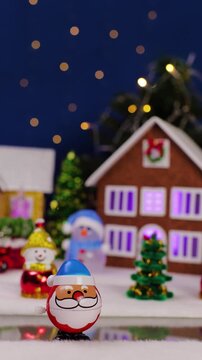 A quirky Santa Claus pops out against the backdrop of a Christmas village